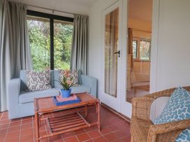 A sunroom with a sofa and table at Maries in Lyme Regis