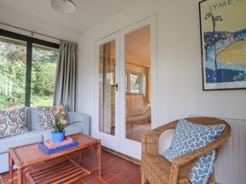 A conservatory with a sofa and coffee table at Maries in Lyme Regis