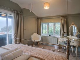 A bedroom with a bed and a mirror at Maries in Lyme Regis