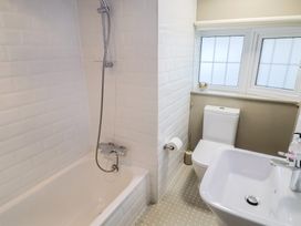 A bathroom with a bathtub, shower, toilet, and sink at Maries in Lyme Regis