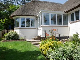 A garden with stone steps and a thatched roof at Maries in Lyme Regis
