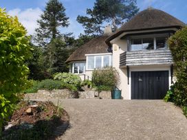 A house with a thatched roof and garden at Maries in Lyme Regis