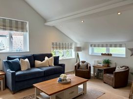 A living room with a sofa and armchairs at 11 The Gables in Lyme Regis