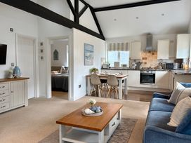 A living room with a sofa and dining area at 11 The Gables in Lyme Regis