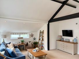 A living room with a sofa and television at 11 The Gables in Lyme Regis
