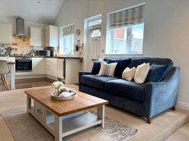 A living room with a blue sofa and coffee table at 11 The Gables in Lyme Regis