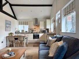 A living room with a kitchen area and dining table at 11 The Gables in Lyme Regis