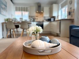 A table with a flower vase and decorative items at 11 The Gables Lyme Regis