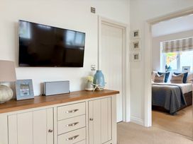 A living room with a television and decorative items at 11 The Gables Lyme Regis