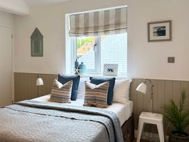A bedroom with a bed and decorative elements at 11 The Gables in Lyme Regis