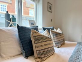 A bed with pillows and decorative items at 11 The Gables in Lyme Regis