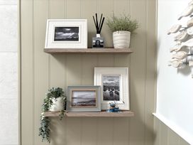 A shelf with photo frames and a plant at 11 The Gables Lyme Regis