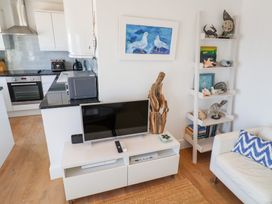 A living room with a television and decorative items at Seagull in Lyme Regis