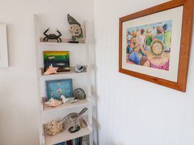 A shelf with seashells and a crab in a living room at Seagull in Lyme Regis