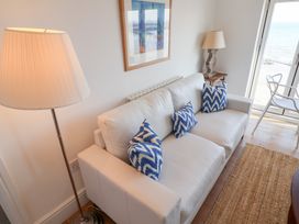 A living room with a sofa and lamp at Seagull in Lyme Regis