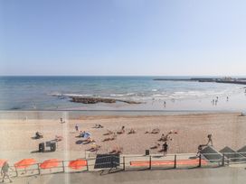 A beach scene with people and an ocean view at Seagull in Lyme Regis