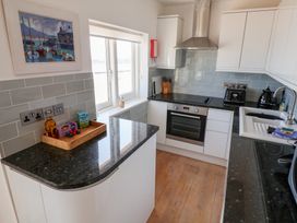 A kitchen with cabinets, countertop, oven and window at Seagull in Lyme Regis