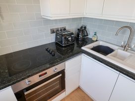 A kitchen with a stove, oven, toaster, kettle, and sink at Seagull in Lyme Regis