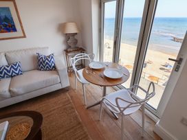 A living room with a dining area and sea view at Seagull in Lyme Regis