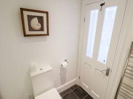 A bathroom with a toilet and door at Seagull in Lyme Regis