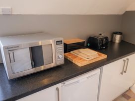 A kitchen counter with a microwave toaster and chopping board at Watersmeet Lyme Regis