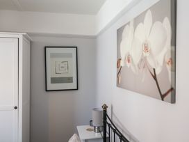 A bedroom with a bed, lamp, and artwork at Watersmeet Lyme Regis