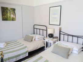 A bedroom with two beds and a bedside table at Watersmeet in Lyme Regis