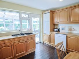 A kitchen with wooden cabinets and appliances at Gosling Way Lyme Regis