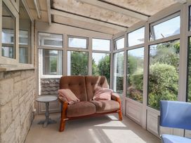 A conservatory with a sofa and side table at Gosling Way Lyme Regis