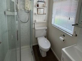A bathroom with a shower and toilet at 8 Bowling Green Chalets in Lyme Regis