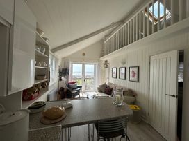 A living room with a kitchen area and seating at 8 Bowling Green Chalets in Lyme Regis