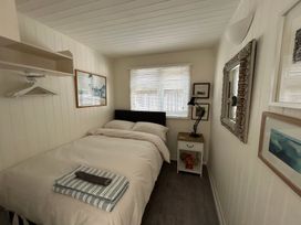 A bedroom with a bed and nightstand at 8 Bowling Green Chalets in Lyme Regis