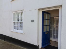 An entrance with a blue front door and window at 3 Dolphin Cottages in Lyme Regis
