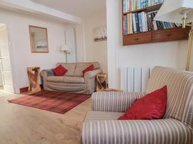 A living room with a sofa and bookshelf at 3 Dolphin Cottages in Lyme Regis