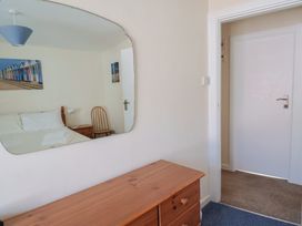 A bedroom with a bed and dresser at 3 Dolphin Cottages in Lyme Regis