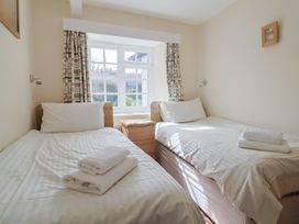 A bedroom with two single beds and a nightstand at 3 Dolphin Cottages in Lyme Regis