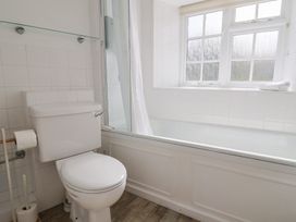A bathroom with a toilet and bathtub at 3 Dolphin Cottages Lyme Regis