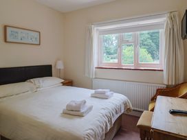A bedroom with a bed and desk at The Orchard Country House in Rousdon