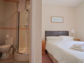 A bedroom with a bed and a shower area at The Orchard Country House in Rousdon