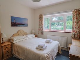 A bedroom with a bed and nightstands at The Orchard Country House in Rousdon