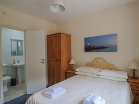 A bedroom with a double bed and an en-suite bathroom at The Orchard Country House in Rousdon