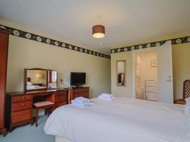 A bedroom with two beds and a television at The Orchard Country House Rousdon