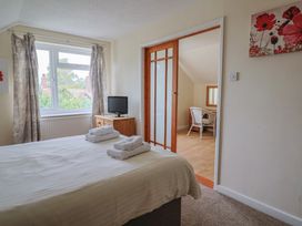 A bedroom with a bed and a television at The Orchard Country House Rousdon