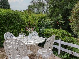 A garden with a table and chairs set at High Trees in Lyme Regis