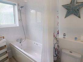 A bathroom with bathtub and shower at High Trees in Lyme Regis