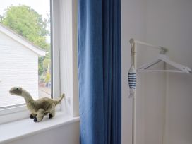 A bedroom window with a toy dinosaur and a clothes hanger at High Trees in Lyme Regis