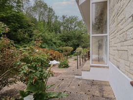 A garden with a pathway and a window at High Trees in Lyme Regis