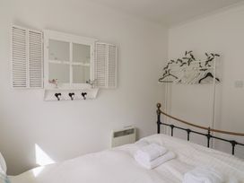 A bedroom with a bed and towels at 1 Bay View Court in Lyme Regis