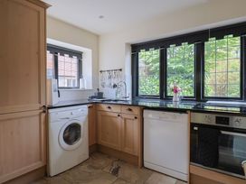 A kitchen with appliances and windows at Yard Cottage in Rousdon
