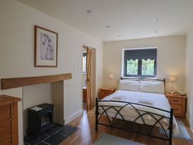 A bedroom with a bed and nightstands at Yard Cottage in Rousdon